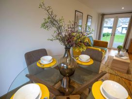 A dining room with a table set and a sofa at Silver Birch Cottage in Llanrwst