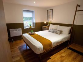 A bedroom with a bed and window at Silver Birch Cottage in Llanrwst