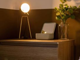 A table with a lamp, mirror, and vase at Silver Birch Cottage in Llanrwst