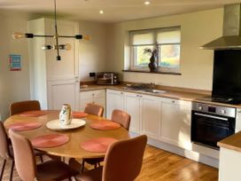 A kitchen with a dining table and chairs at River View Cottage Llanrwst