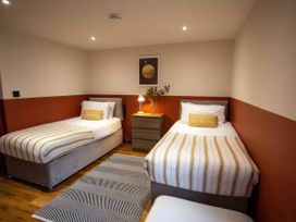 A bedroom with two beds and a nightstand at Mountain View Cottage in Llanrwst