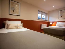 A bedroom with two beds and a window at Mountain View Cottage Llanrwst