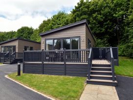 A cabin with a deck and steps at The Falls in Leyburn