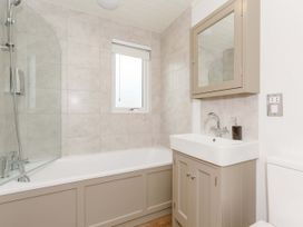 A bathroom with a bathtub, sink, and shower at Wensleydale (Pet) in Aysgarth