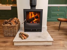 A fireplace with logs and basket in a living room at Fairview in Darsham