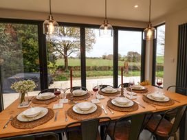 A dining room with a set table overlooking fields at Fairview in Darsham