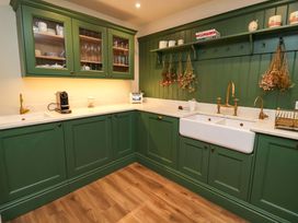 A kitchen with green cabinets and a white sink at Fairview in Darsham