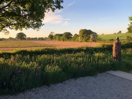 A view of a field with a sculpture and trees at Fairview in Darsham