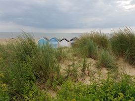 A beach with huts in the background at Fairview in Darsham