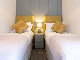 A bedroom with two beds and a lamp on a nightstand at The Falls (Pet) Leyburn