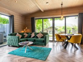 A living room with a green sofa and yellow chairs at Middleham in Leyburn