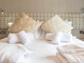 A bedroom with bedding and decorative pillows at Bainbridge Leyburn