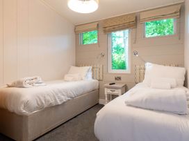 A bedroom with two beds and a bedside table at Bainbridge in Leyburn