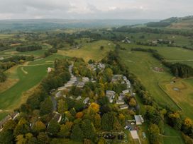 An aerial view of houses surrounded by fields and trees at Bainbridge Aysgarth
