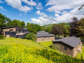 A view of cabins surrounded by grass and trees at Bainbridge in Aysgarth