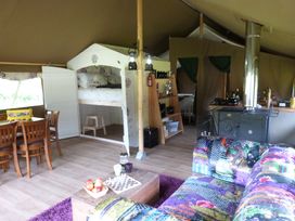 An indoor living space with a sofa, table, and kitchen area at Aeron in Newcastle Emlyn