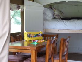 A dining area with a table and chairs and a bed overhead at Aeron in Newcastle Emlyn