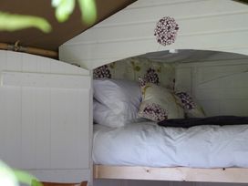 A sleeping area with a bed and cushions at Aeron Newcastle Emlyn