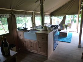 A kitchen with a sink and stove in a tent at Teifi Newcastle Emlyn