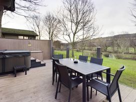 An outdoor patio with a hot tub and table at Leyburn