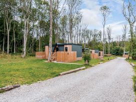 A lodge with wooden fencing and a gravel pathway at Tennyson Spa in Louth