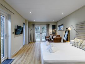 A bedroom with a bed and sofa at Tennyson Spa in Louth