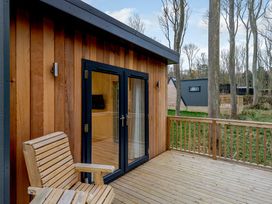 An outdoor area with a wooden deck and chair at Tennyson Spa Louth
