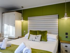 A bedroom with a bed and wardrobe at Somersby Spa (Pet) in Louth