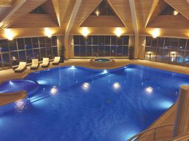 An indoor pool with lounge chairs and a spa at Somersby Spa (Pet) in Louth