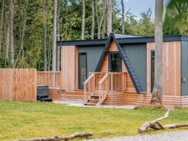 A wooden cabin with stairs and decking in an outdoor area at Tennyson Spa (Pet) Louth