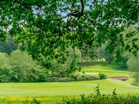 An outdoor landscape with trees and a bridge at Tennyson Spa (Pet) in Louth