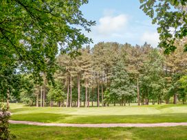 A golf course with trees and a pathway at Tennyson Spa (Pet) in Louth