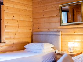 A bedroom with a bed and bedside table at Maple Lodge in Louth