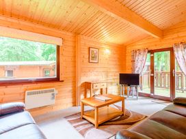 A living room with wooden walls and a coffee table at Maple Lodge in Louth