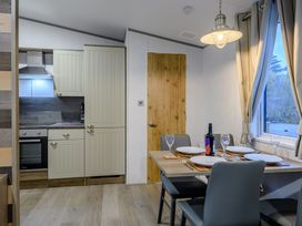 A dining room with a table and kitchen cabinets at Anderby Spa (Pet) Louth