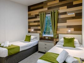 A bedroom with twin beds and a nightstand at Anderby Spa (Pet) Louth