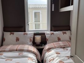 A bedroom with two beds and a lamp at No 19 Cliff top park Hartlepool