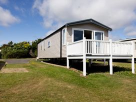 A mobile home with a deck and grass area at No 19 Cliff top park Hartlepool