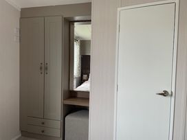 A bedroom with a wardrobe and mirror at No 19 Cliff top park in Hartlepool