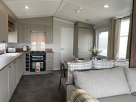 A kitchen with a stove, oven, and dining table at No 19 Cliff top park, Hartlepool
