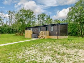 A house with a deck and steps surrounded by grass at Horncastle Plus in Louth