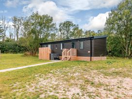 A mobile home with wooden deck and stairs at Horncastle Spa Plus in Louth