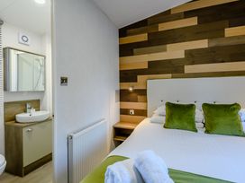 A bedroom with a bed and bathroom visible at Horncastle Spa Plus in Louth