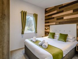 A bedroom with a bed and curtains at The Kinder Spa (Pet) in Louth