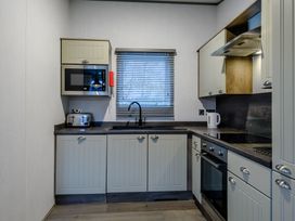 A kitchen with cabinets and appliances at The Kinder Spa (Pet) Louth