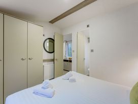 A bedroom with a bed and wardrobe at Horncastle Spa Plus (Pet) in Louth