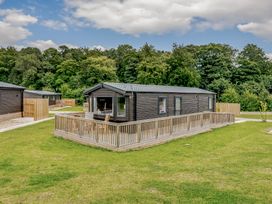 A cabin with decking surrounded by grass and trees at Alford WF in Louth