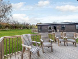 An outdoor area with wooden chairs and a cabin at Alford WF in Louth