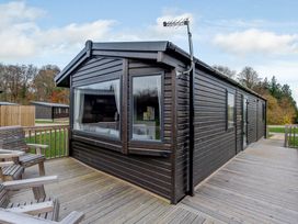 A cabin exterior with a deck and seating at Alford WF in Louth