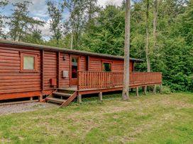 An outdoor view of a cabin with a deck at Cedar Lodge in Louth
